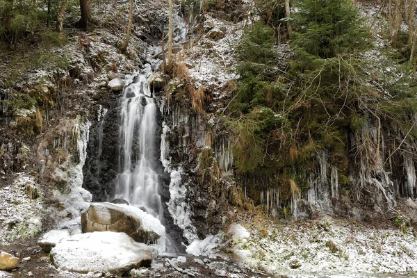 Cascata ghiacciata nella foresta ghiacciata con neve — Foto Stock