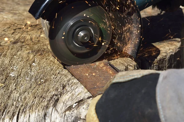 Molinillo eléctrico. Un hombre que trabaja con la herramienta eléctrica de la amoladora en la estructura de acero, chispas volando —  Fotos de Stock