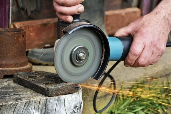 Electric grinder. A man working with electric grinder tool on steel structure, sparks flying