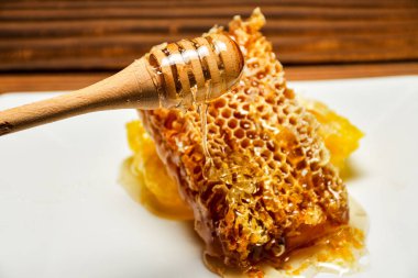 Taze peteğin ve ahşap bir masa üzerine dökerek bal ile ahşap Kepçe