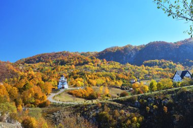 Romen Köyü Kilisesi, yollar ve çayırlar üzerinde ön plan ve dağ zirveleri gündoğumu, arka plan üzerinde renkli sonbahar sahne.