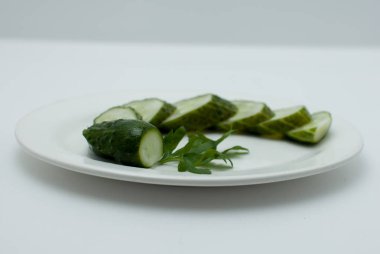 Beyaz bir tabakta dilimlenmiş salatalık.