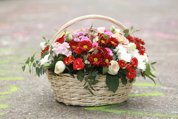 flowers in a basket on the pavement