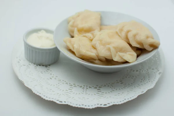 Dumplings with sour cream on the plate — Stock Photo, Image