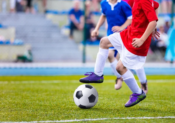 Unga pojkar spelar fotbollsmatch. Barn sparka fotboll på idrottsplats — Stockfoto