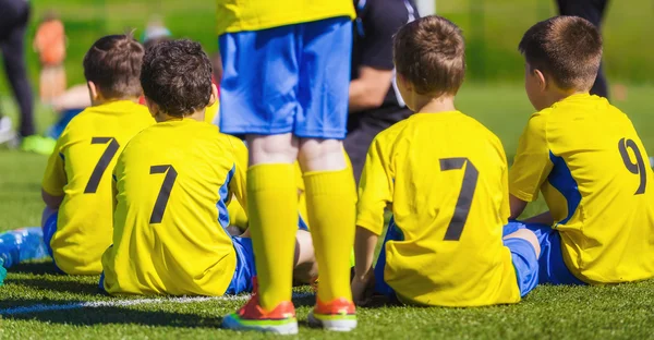 Genç erkek birlikte bir bankta oturan bir futbol futbol olarak. Çocuklar oyun oynamaya hazır — Stok fotoğraf