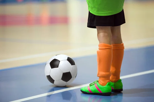 Futbol futsal eğitim çocuklar için. Kapalı futbol bir spor salonunda bir futbol topu ile genç oyuncu. Spor arka plan.