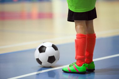 Futbol futsal eğitim çocuklar için. Kapalı futbol bir spor salonunda bir futbol topu ile genç oyuncu. Sarı ve kırmızı Tekdüzen oyuncunun. Spor arka plan.