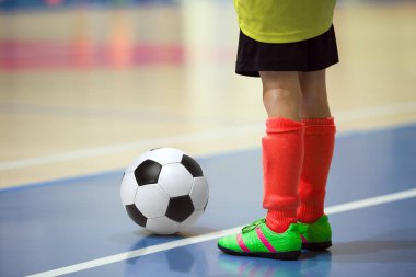 Futbol futsal eğitim çocuklar için. Kapalı futbol bir spor salonunda bir futbol topu ile genç oyuncu. Sarı ve kırmızı Tekdüzen oyuncunun. Spor arka plan.