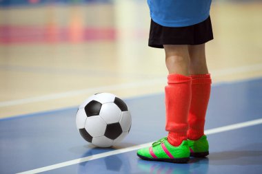 Futbol futsal eğitim çocuklar için. Kapalı futbol bir spor salonunda bir futbol topu ile genç oyuncu. Mavi ve kırmızı Tekdüzen oyuncunun. Spor arka plan.