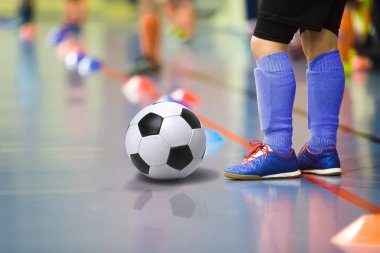 Futbol futsal kapalı spor salonu eğitim çocuk. Futbol topu eğitim kapalı futbol genç çocuk. Koyu mavi spor çoraplar küçük oyuncu