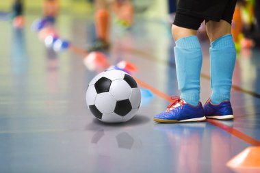 Futbol futsal kapalı spor salonu eğitim çocuk. Futbol topu eğitim kapalı futbol genç çocuk. Küçük oyuncu ışık mavi spor çoraplar