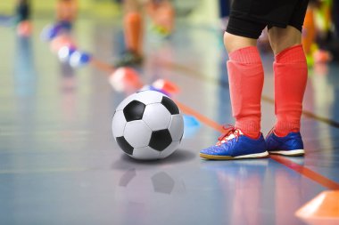 Futbol futsal kapalı spor salonu eğitim çocuk. Futbol topu eğitim kapalı futbol genç çocuk. Işık kırmızı spor çoraplar küçük oyuncu