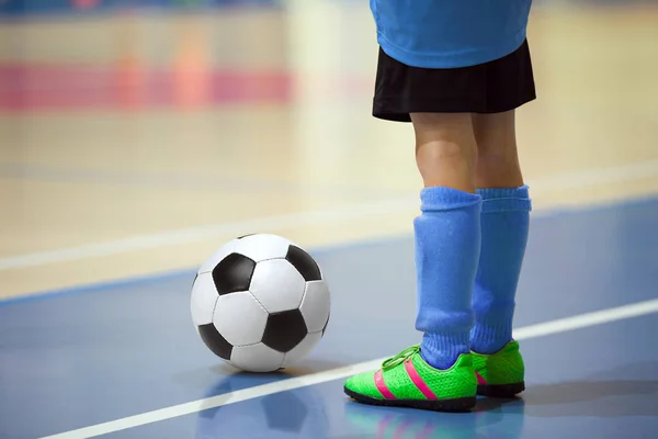 Futbol futsal eğitim çocuklar için. Kapalı futbol bir spor salonunda bir futbol topu ile genç oyuncu. Oyuncu mavi üniformalı. Spor arka plan.
