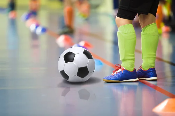 Bambini che allenano calcetto palestra coperta. Giovane ragazzo con allenamento di pallone da calcio indoor football. Piccolo giocatore in calzini sportivi verde chiaro — Foto Stock