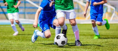 Futbol futbol oyuncuları çalıştırıyor. Futbolcular tekme futbol maçı oyunu. Genç futbol oyuncular topun peşinde koşuyoruz. Futbol Stadyumu içinde belgili tanımlık geçmiş