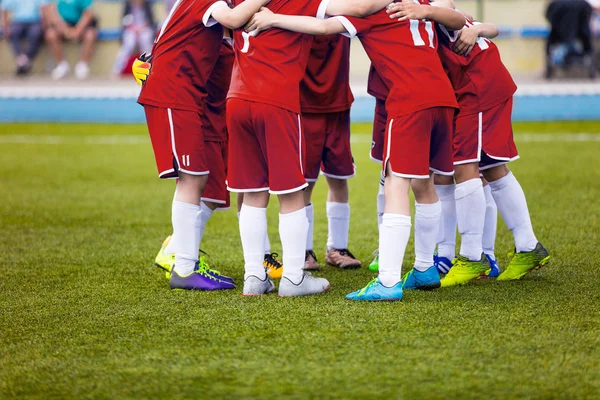 Unga fotbollsspelare fotboll i röda sportkläder. Ung sport team på planen. Peptalk innan sista matchen. Fotboll skola turnering. Barn på idrottsplats. — Stockfoto