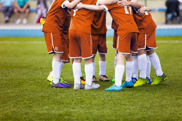 Mladé fotbalové fotbalistů v oranžové sportovní oblečení. Mladý sportovní klub na hřišti. Povzbuzení před finále. Fotbalový turnaj školy. Děti na sportovním poli. — Stock fotografie