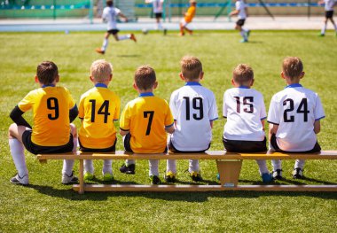 Genç futbolcular. Tahta bankta oturan genç futbol takımı. Çocuklar için futbol maçı. Turnuva futbol maçı oynayan genç erkek. Gençlik futbol kulübü futbol takımı oyuncuları