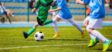 Futbol futbol oyuncuları çalıştırıyor. Futbolcular tekme futbol maçı oyunu. Genç futbol oyuncular topun peşinde koşuyoruz. Futbol Stadyumu içinde belgili tanımlık geçmiş