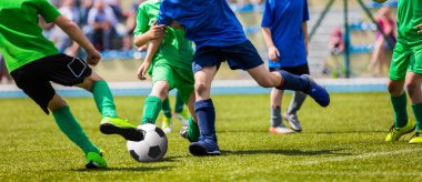 Genç futbolcular futbol çalışan. Futbol tekme futbolcular oyun aynı. Gençlik futbol oyuncular topun peşinde koşuyoruz. Futbol Stadyumu içinde belgili tanımlık geçmiş