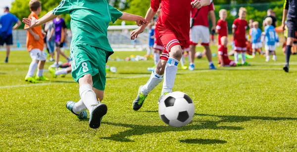 孩子们在运动场上玩足球足球游戏。男孩在绿色草地上玩的足球比赛。青年足球锦标赛小组比赛 — 图库照片