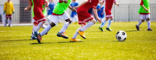 Genç futbolcular futbol çalışan. Futbol tekme futbolcular oyun aynı. Gençlik futbol oyuncular topun peşinde koşuyoruz. Yatay Futbol Stadyumu arka plan