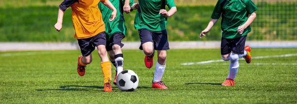 Giocatori di calcio giovanile in esecuzione. Bambini che giocano a calcio sul campo sportivo. I ragazzi giocano a calcio su erba verde. Torneo giovanile di calcio Squadre Concorso . — Foto Stock