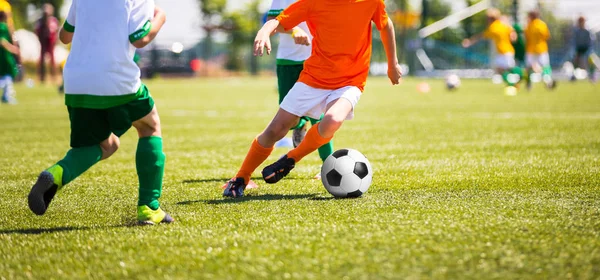 Pojkar sparka fotboll. Barn fotbollslag. Barn kör med boll på fotbollsplan. Unga fotbollspelare i aktion — Stockfoto