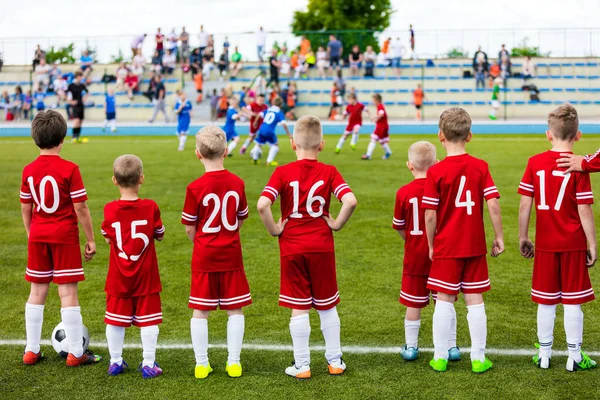 Boys Play Soccer Match. Children Sport Team. Youth Sports Team Together. Football Soccer Game For Children. Kids Soccer Players on bench Watching Tournament Game with Coach — Stock Photo, Image