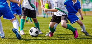 Genç erkek futbol oyuncuları Futbol Spor sahada tekme. Mavi ve beyaz formaları çalışan futbolcular. Futbol yatay arka plan