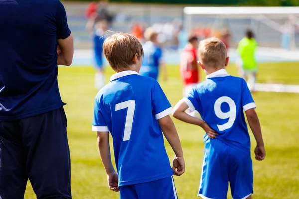 Jóvenes jugadores deportivos con entrenador. Niños jugadores de fútbol. Torneo de fútbol escolar para niños —  Fotos de Stock