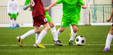 Çocuklar futbol futbol oyunu tekme. Genç futbolcular çalıştırıyor. Çocuklar spor sahada futbol maçı oyun