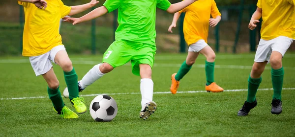 Jongens schoppen Soccer voetbalspel. Uitvoeren van jonge voetballers. Kinderen spelen van de voetbalwedstrijd op het sportveld — Stockfoto