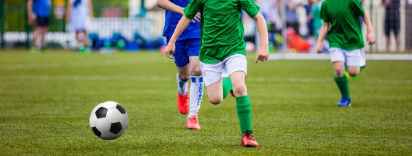 Junge kicken Fußball auf dem Sportplatz — Stockfoto