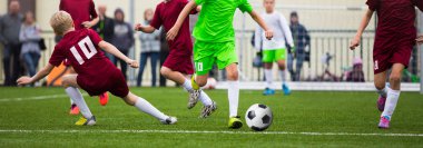 Çocuk futbol futbol oyuncuları. Futbolcular futbol tekme çimenlerin üzerinde oyun aynı. Genç futbol oyuncular topun peşinde koşuyoruz. Yatay gençlik spor arka plan