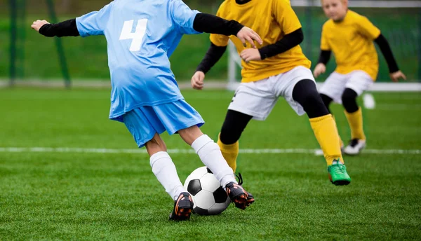 Partido de fútbol para niños. Niños jugando al torneo de fútbol. Chicos corriendo y pateando el fútbol en el campo de hierba deportiva —  Fotos de Stock