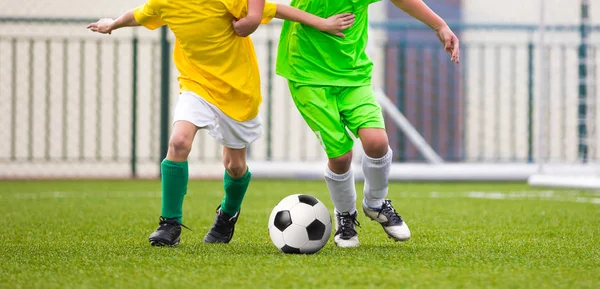Laufende Kinder-Fußballer mit Ball. Fußballer kicken Fußballspiel auf dem Platz. junge Teen Fußballspiel. Hintergrund des Jugendsports — Stockfoto
