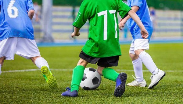 Fußballer läuft mit dem Ball auf dem Platz. Fußballer kicken Fußballspiel auf dem Platz. junge Teen Fußballspiel. Hintergrund des Jugendsports — Stockfoto
