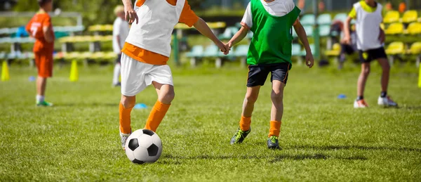 Kinderen opleiding van voetbal. Jonge jongens spelen van de voetbalwedstrijd op worp. Kinderen lopen met voetbal. Voetbal trainingssessie voor kinderen — Stockfoto