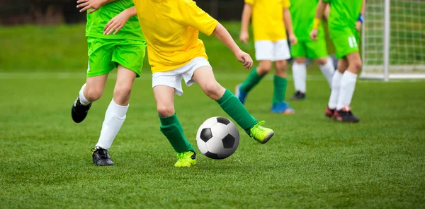 Labdarúgó játékos fut a labdával a pályán. Labdarúgók rugdossa a labdarúgó-mérkőzés a pályán. Fiatal tini foci játék. Ifjúsági Sport háttér — Stock Fotó