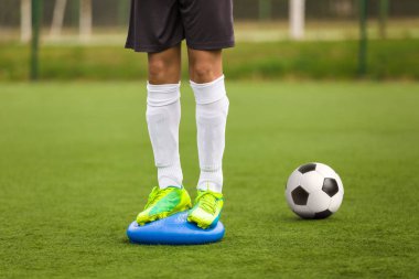 Spor eğitim dengesi. İstikrar futbol eğitim denge yastık üzerinde. Futbol becerileri eğitimi oturum. Oyuncular sahada eğitim. Çim futbol sahası. Futbol ekipmanları alanında eğitim için koçluk