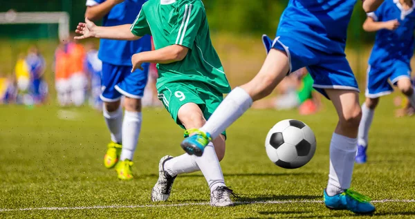 Giocatore di calcio in esecuzione con la palla sul passo. I calciatori che calciano la partita di calcio sul campo. Giovane partita di calcio adolescente. Sfondo sportivo giovanile — Foto Stock