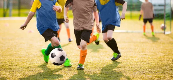 Niños jugando al torneo de fútbol. Partido de fútbol para niños. Chicos corriendo y pateando fútbol. Entrenador de fútbol juvenil en el fondo —  Fotos de Stock