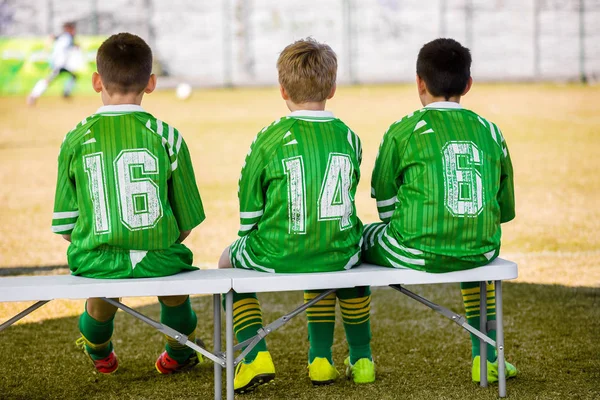 Equipa de futebol infantil. Young Boys Reserve Jogadores sentados no banco e assistindo Jovens Futebol Match. Escola Futebol Jogo de futebol — Fotografia de Stock