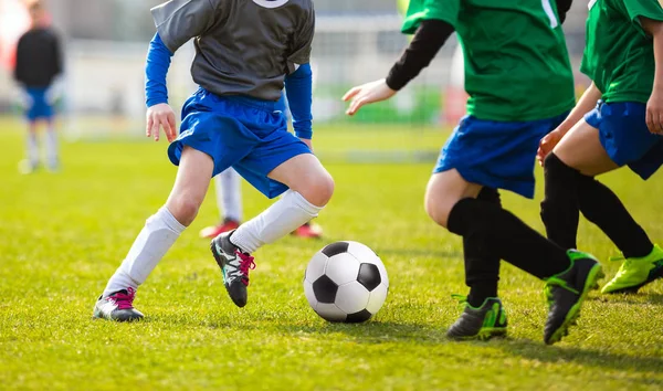 子供のサッカーのサッカー試合。子供たちのサッカー ゲーム大会です。男の子を実行し、サッカー ボールを蹴るします。バック グラウンドでサッカーのピッチ — ストック写真