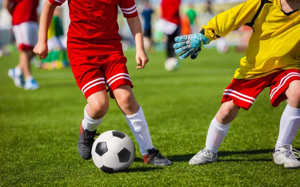 Chicos con balón de fútbol. Niños jugando fútbol partido de fútbol. Youth Soccer Forward and Goalkeeper Duel (en inglés). Juego de fútbol. Jugadores futbolistas corriendo y jugando fútbol partido — Foto de Stock