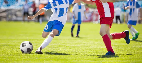 Ação do jogador de futebol no estádio. Jogo de Torneio de Futebol Jovem. Jovens meninos correndo e chutando bola de futebol em Green Soccer Pitch . — Fotografia de Stock