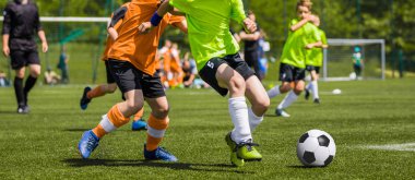Genç erkek futbol futbol maçı sahada oynuyor. Çalışan ve yeşil çimenlerin üzerinde futbol topu tekmeleme çocuklar. Futbol çocuk oyunu