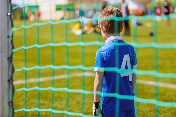 Niño joven como portero de fútbol durante el partido de fútbol listo para salvar —  Fotos de Stock